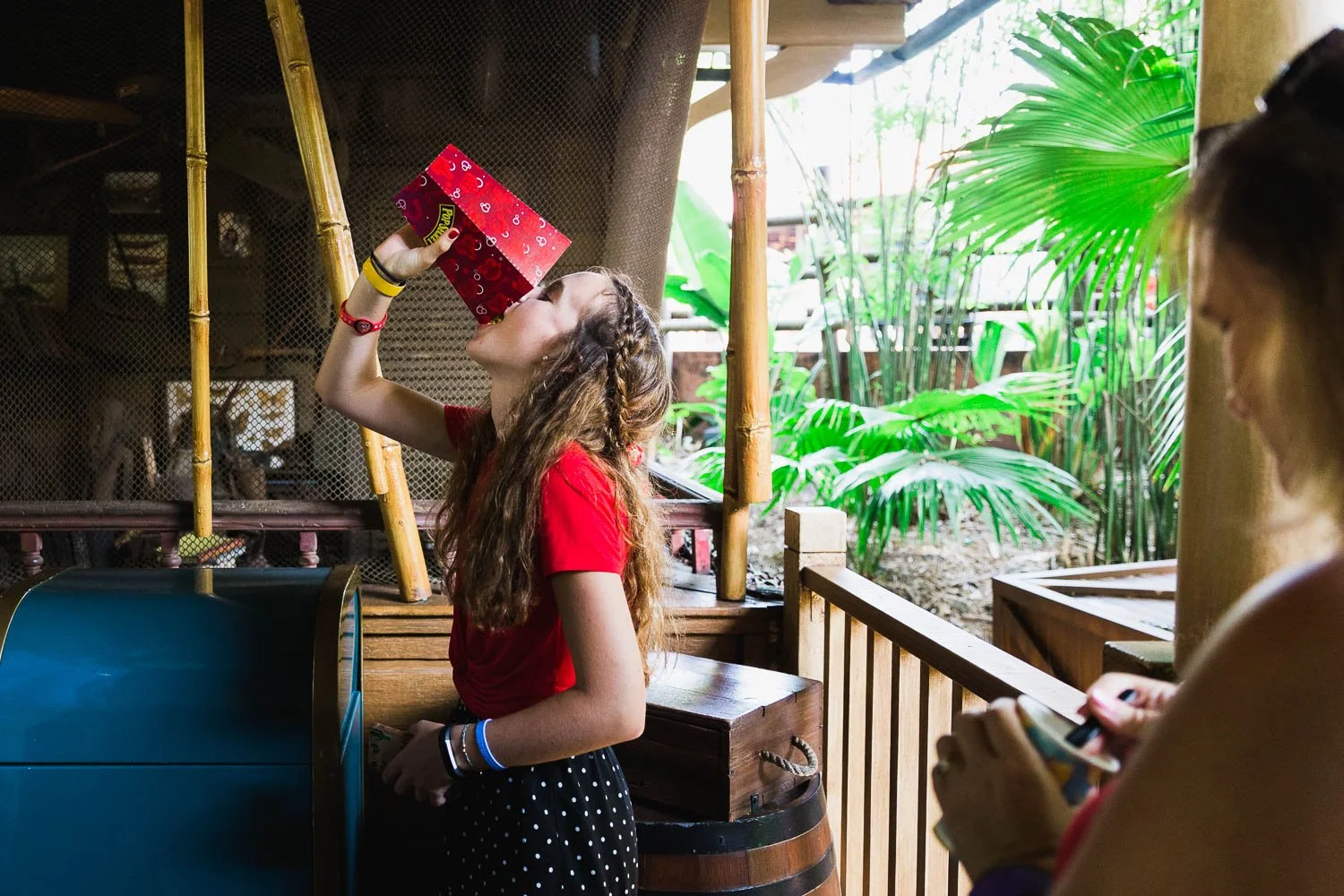 Teen dumps popcorn into her mouth to finish the bucket.