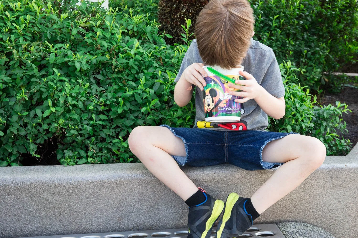 Boy sticks his whole head in popcorn bucket at Magic Kingdom.