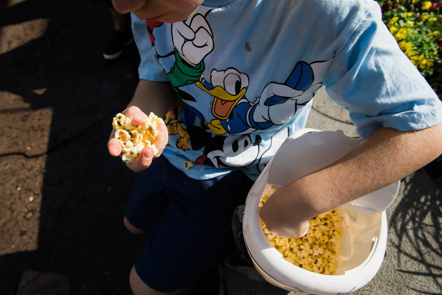 Kid with a handful of popcorn at Storybook Circus.