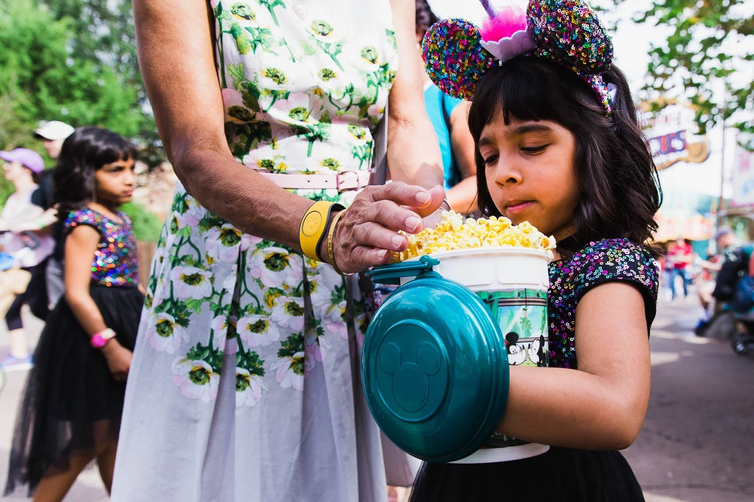 Grandmother and granddaughter share popcorn at Magic Kingdom.