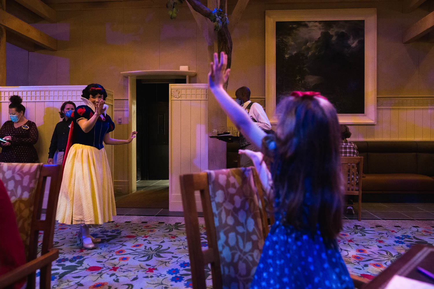 Girl waves to Snow White at Artist's Pointe character dinner.