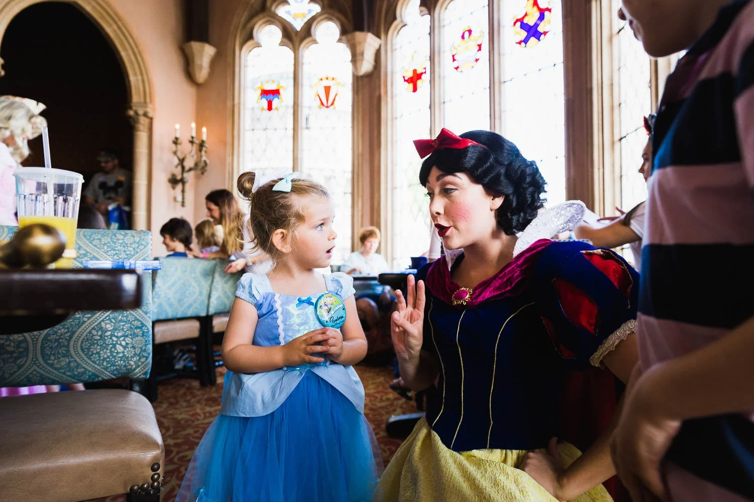 Little girl tells Snow White it's her birthday at Cinderella's Royal Table at the Magic Kingdom.