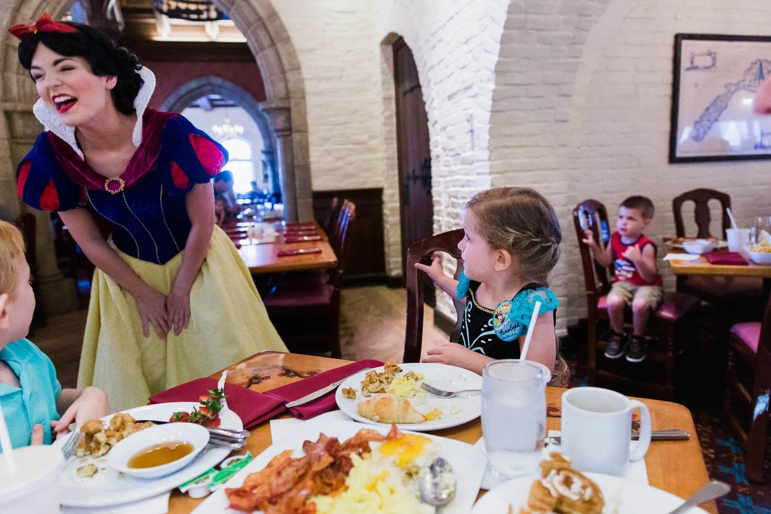 Snow White laughs with family at breakfast at Akershus in Norway pavilion.