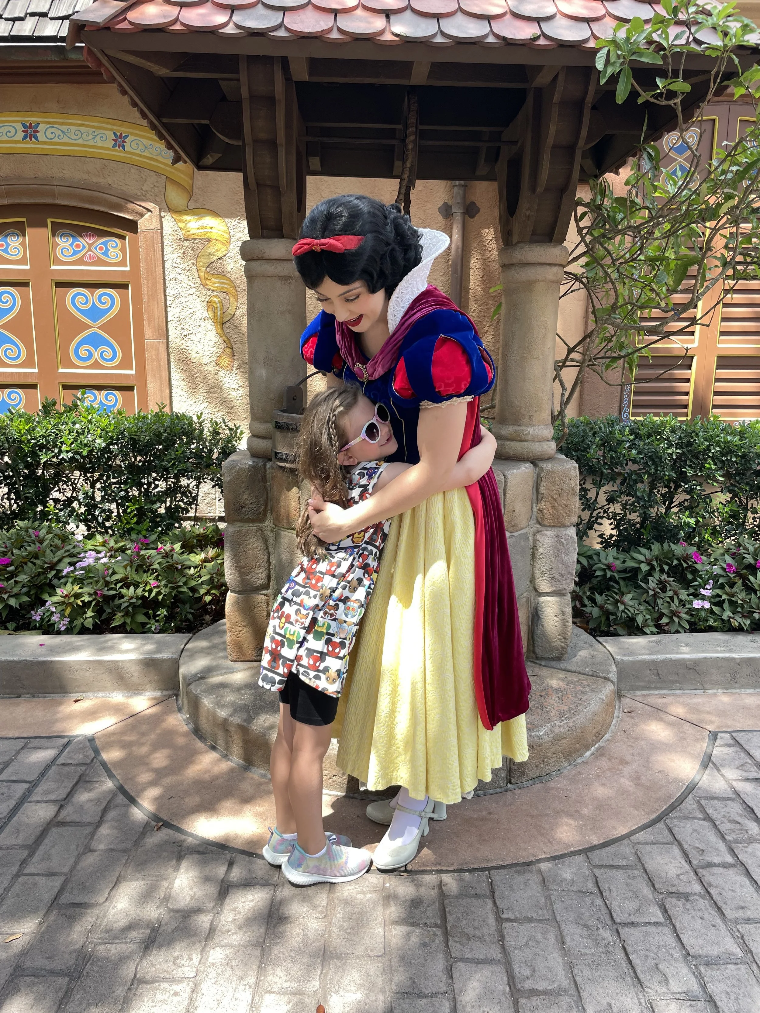 Little girl hugs Snow White in the Germany Pavilion at Epcot.