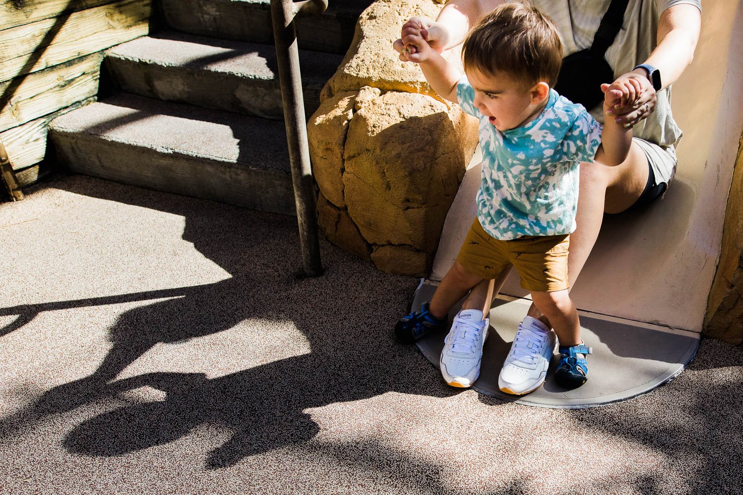 Mom slides with her son in the Boneyard place space at the Animal Kingdom.