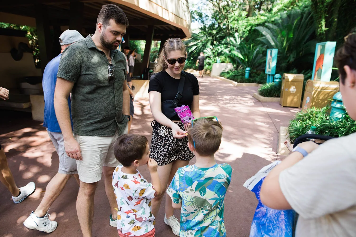 Aunt and uncle offer candy to their nephews at the Animal Kingdom.