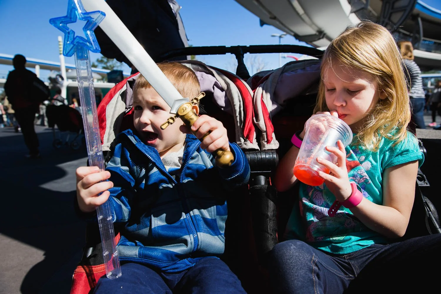 Siblings enjoy a snack in their stroller at the Magic Kingdom.