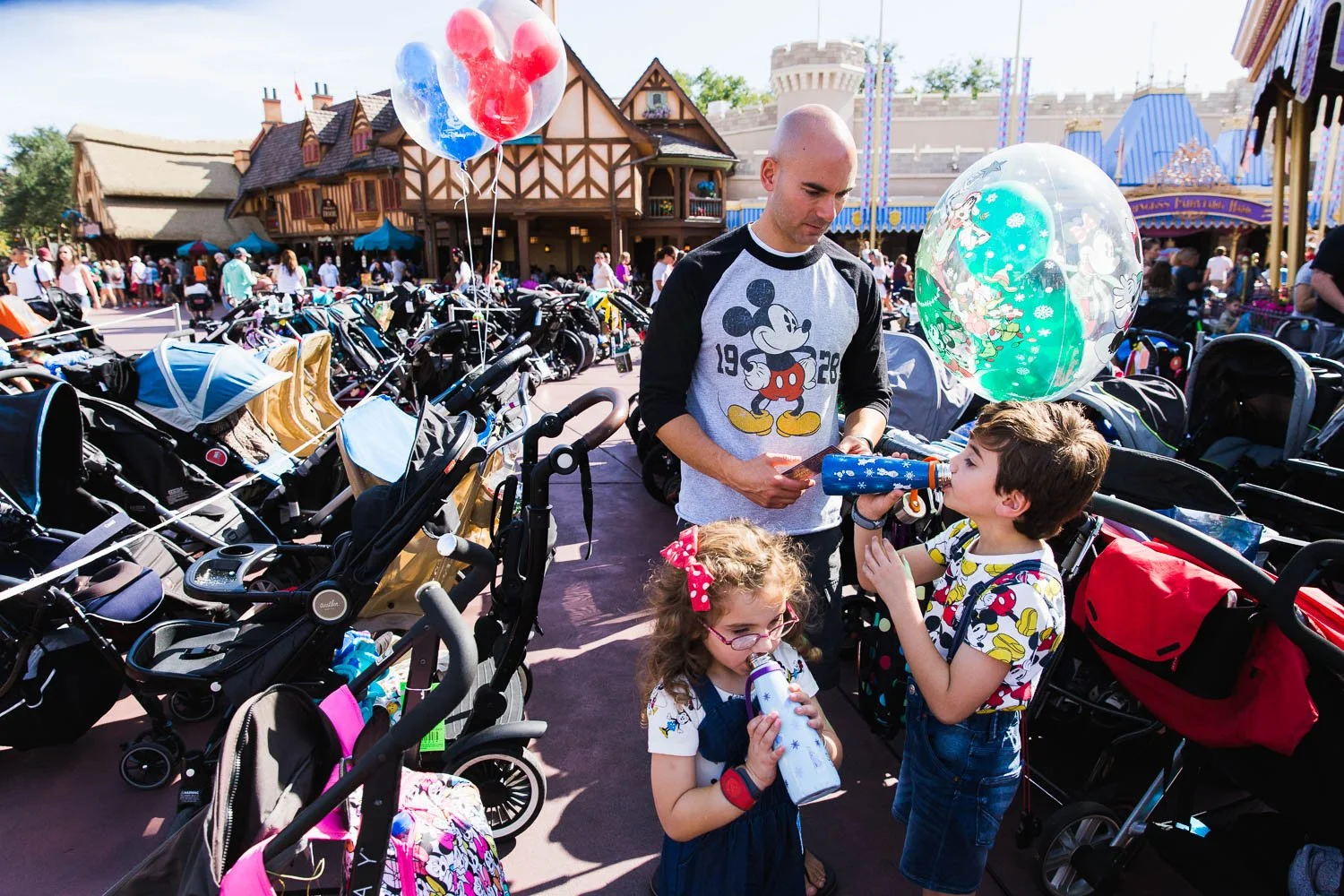 Family hydrates in the stroller parking area in Fantasyland at the Magic Kingdom.
