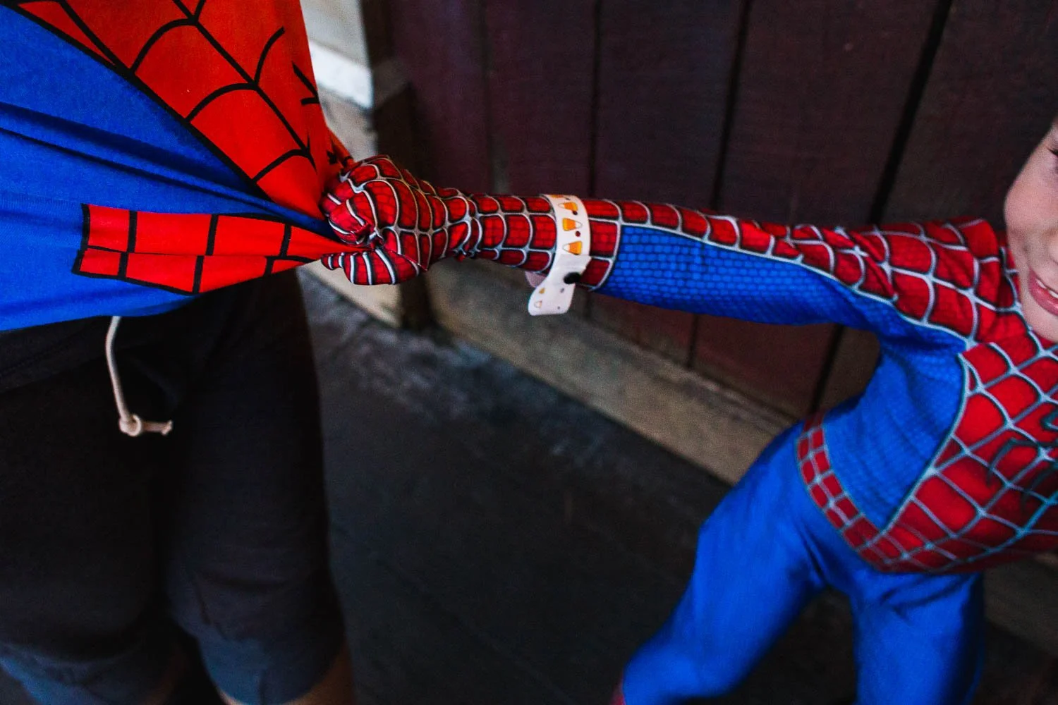 Boy pulls on mother's shirt while in the queue of a Disney attraction.