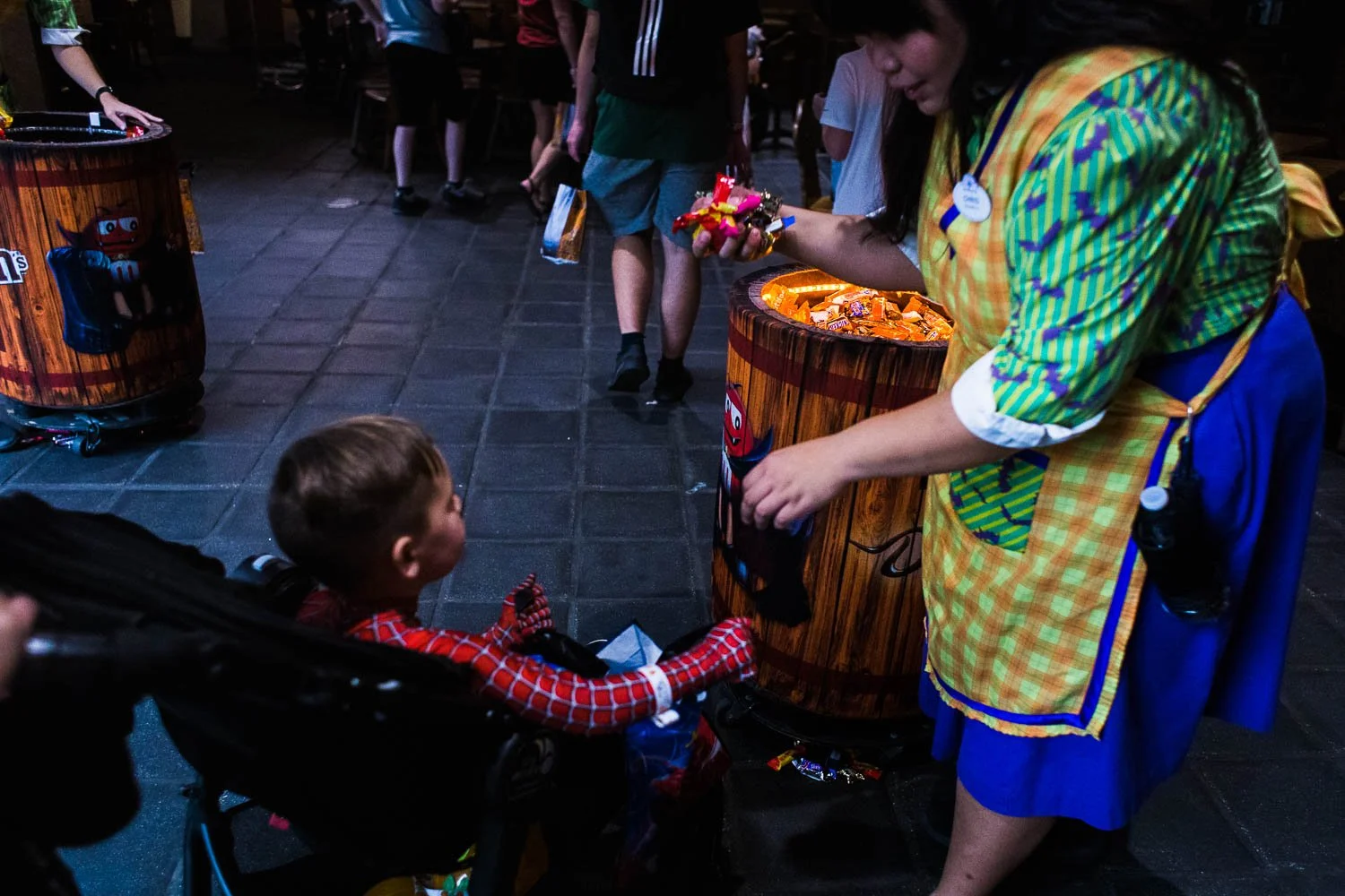 Cast Member fills little boy's treat bag with candy at Mickey's Not So Scary Halloween Party.