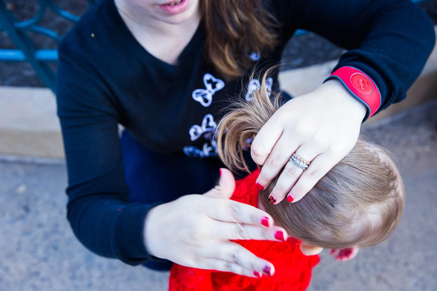 Mother fixes her daughter's ponytail at Hollywood Studios.