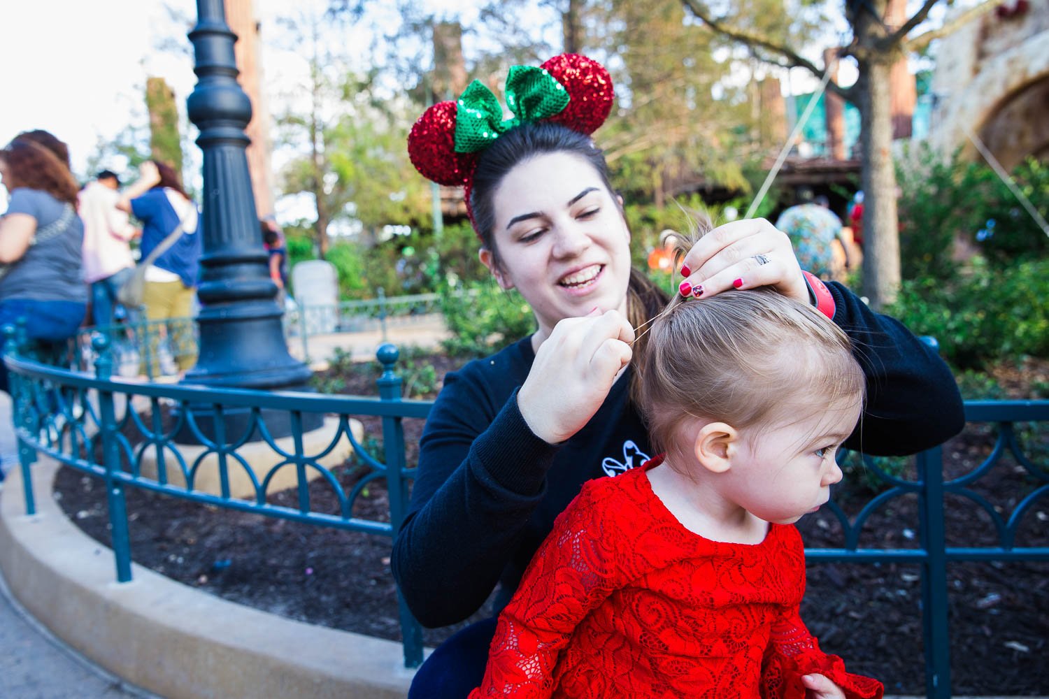 Mom puts daughter's hair into ponytail at Hollywood Studios.