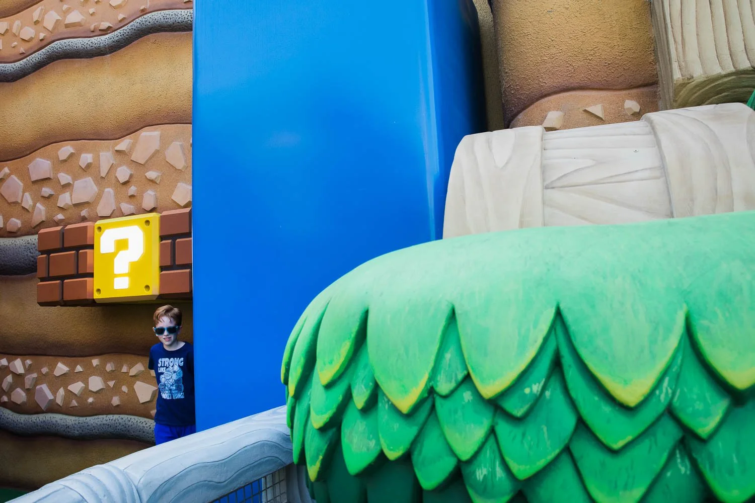 Tween stands under power up block in Super Nintendo World at Epic Universe.