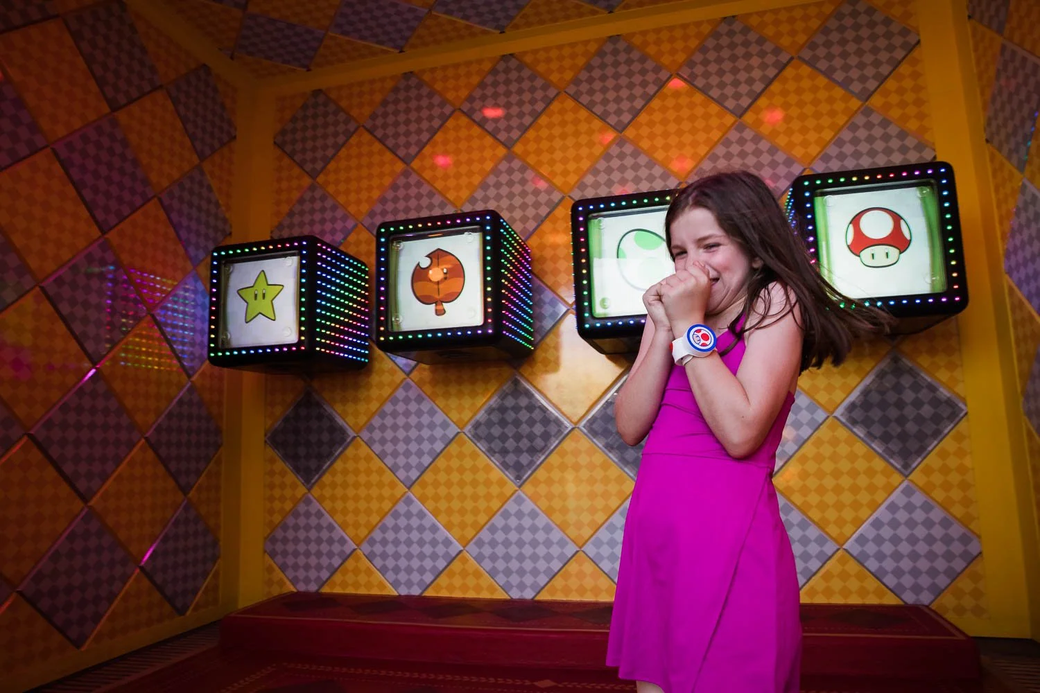 Girl plays power up slot machines in Super Mario World at Universal theme park.