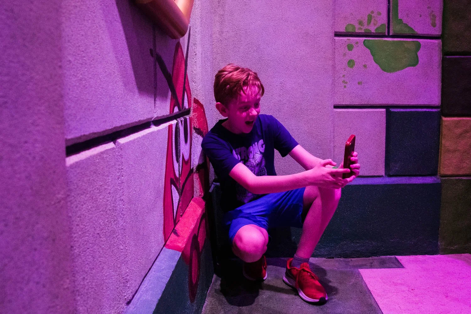 Tween boy takes a selfie with a goomba in Bowser's Castle at Epic Universe.