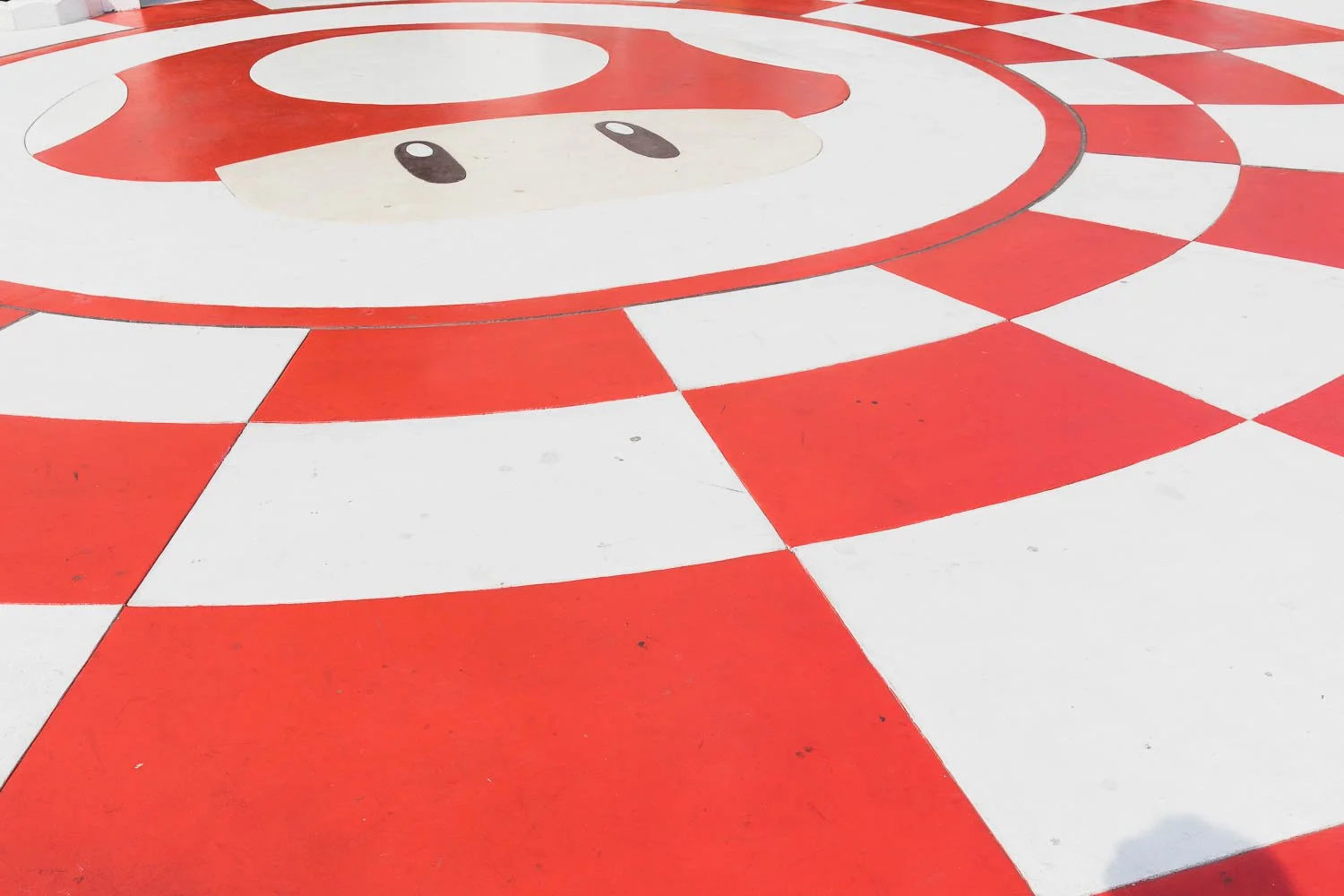 Vibrant red and white mushroom on the concrete in Super Nintendo World.