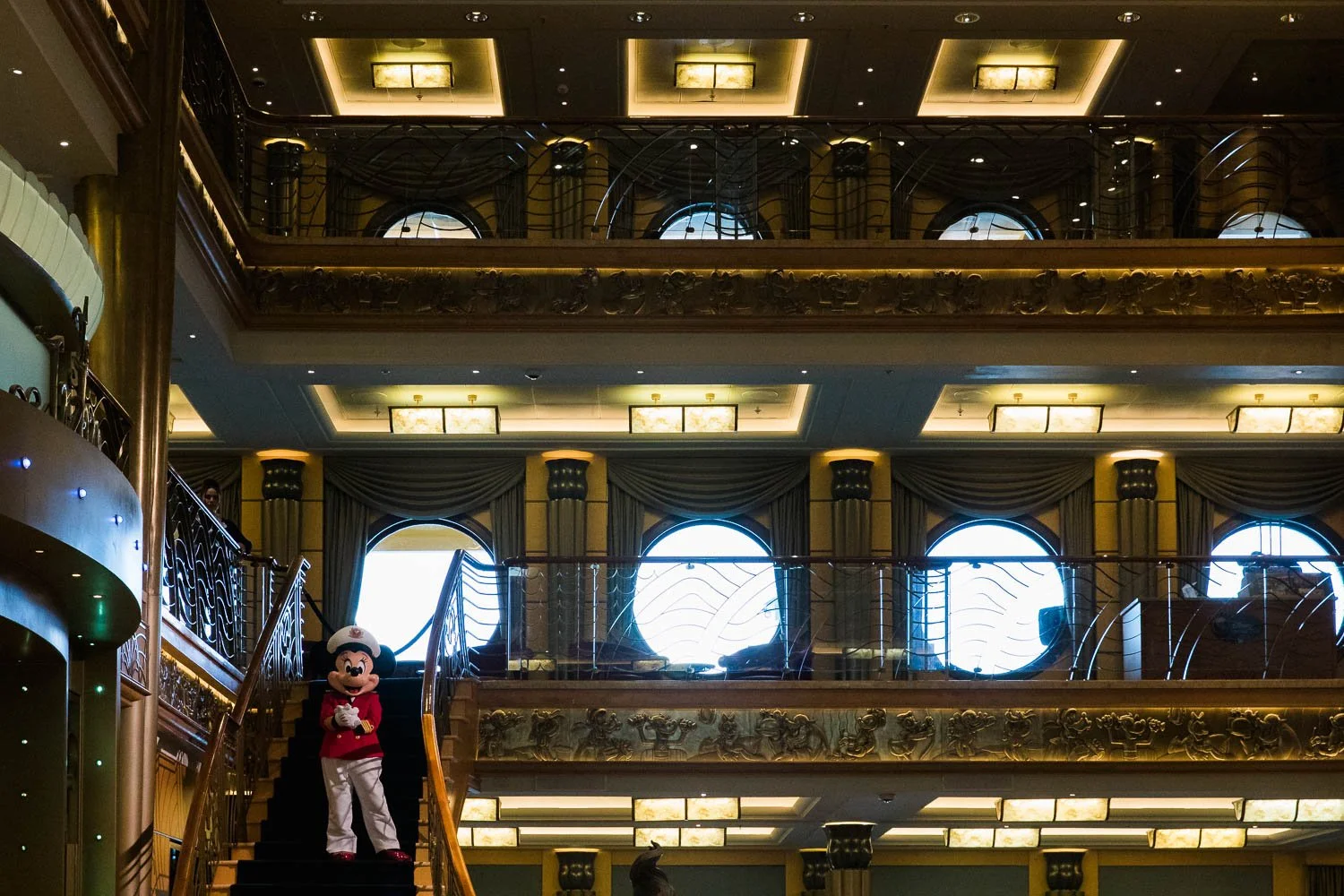 Captain Minnie Mouse greeting guests in the atrium of the Disney Wonder.