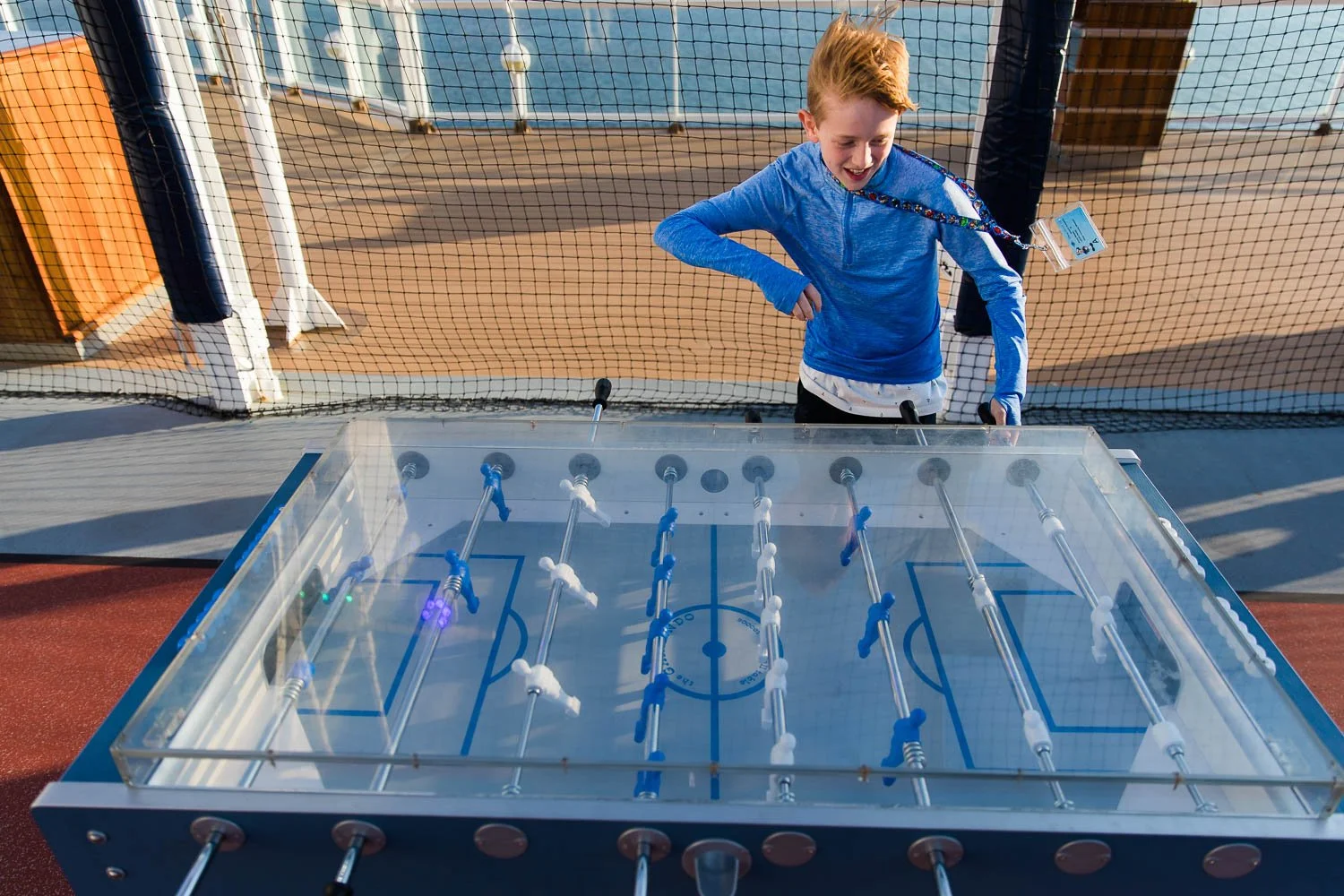 Boy plays foosball on the Disney Wonder.