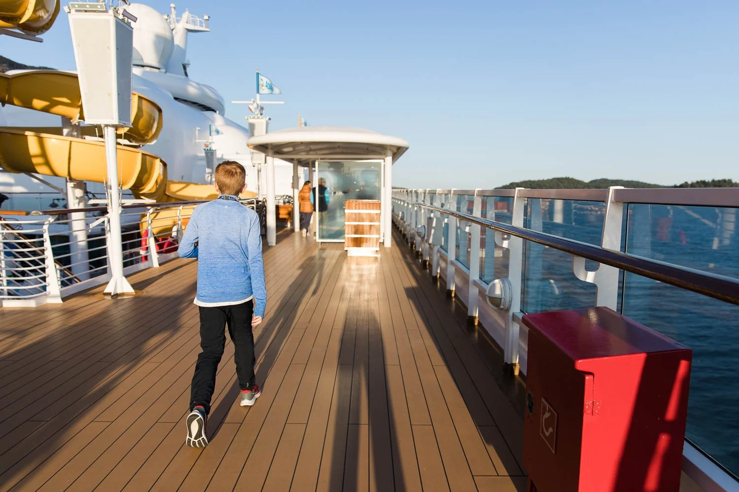 Boy walks across the top deck of the Disney Wonder.