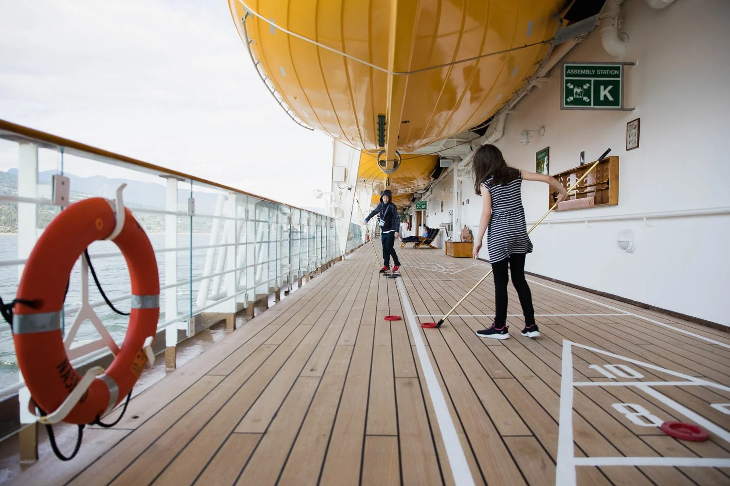 Brother and sister play shuffleboard on the Disney Wonder.