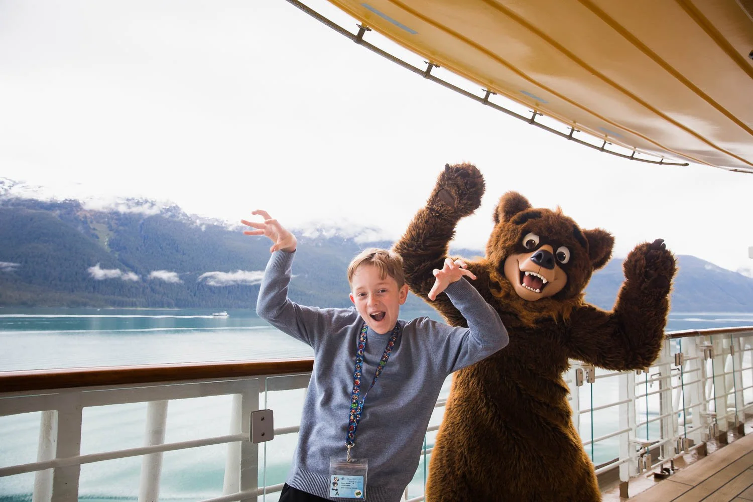 Boy does a "bear pose" with Koda on deck four of the Disney Wonder as it sails through Alaska.