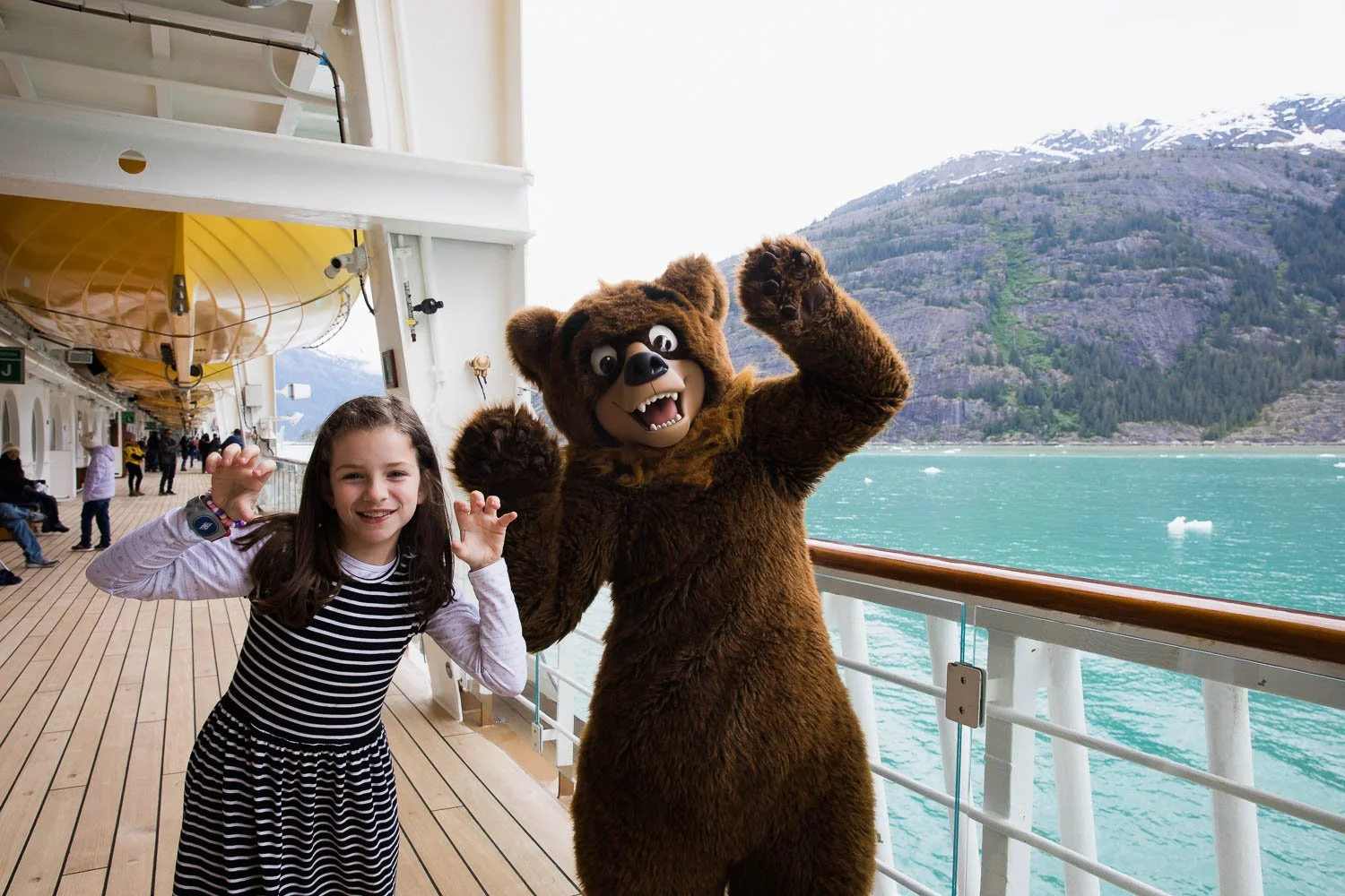 Girl makes "bear paw" hands with Koda in Alaska.
