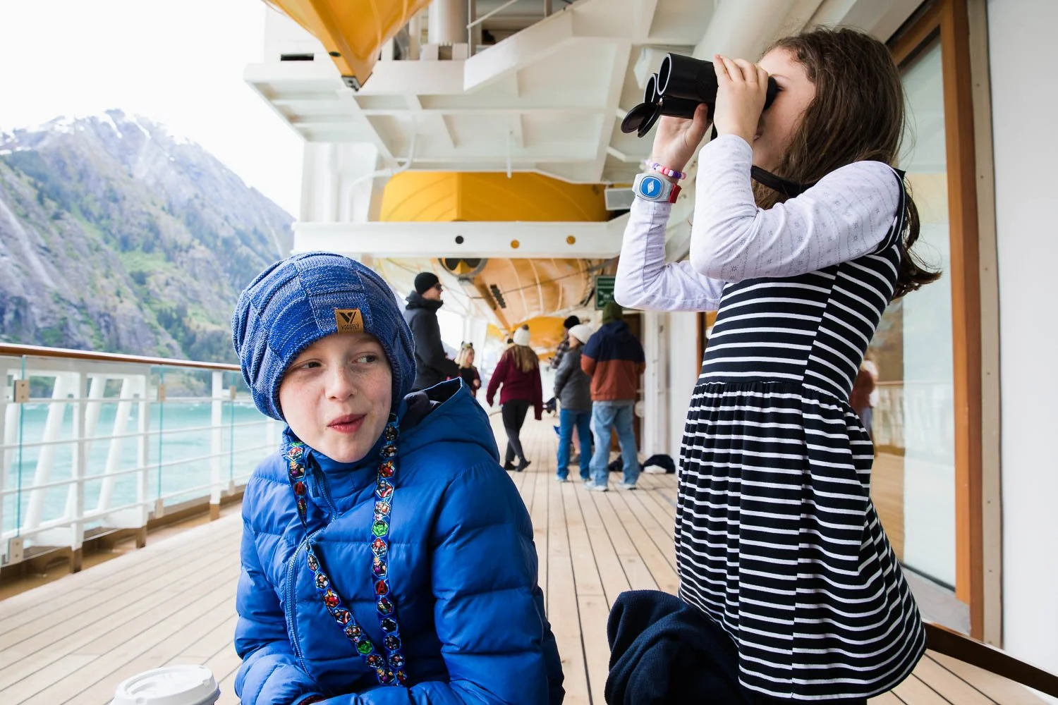 Siblings take turns using binoculars on the Disney Wonder.