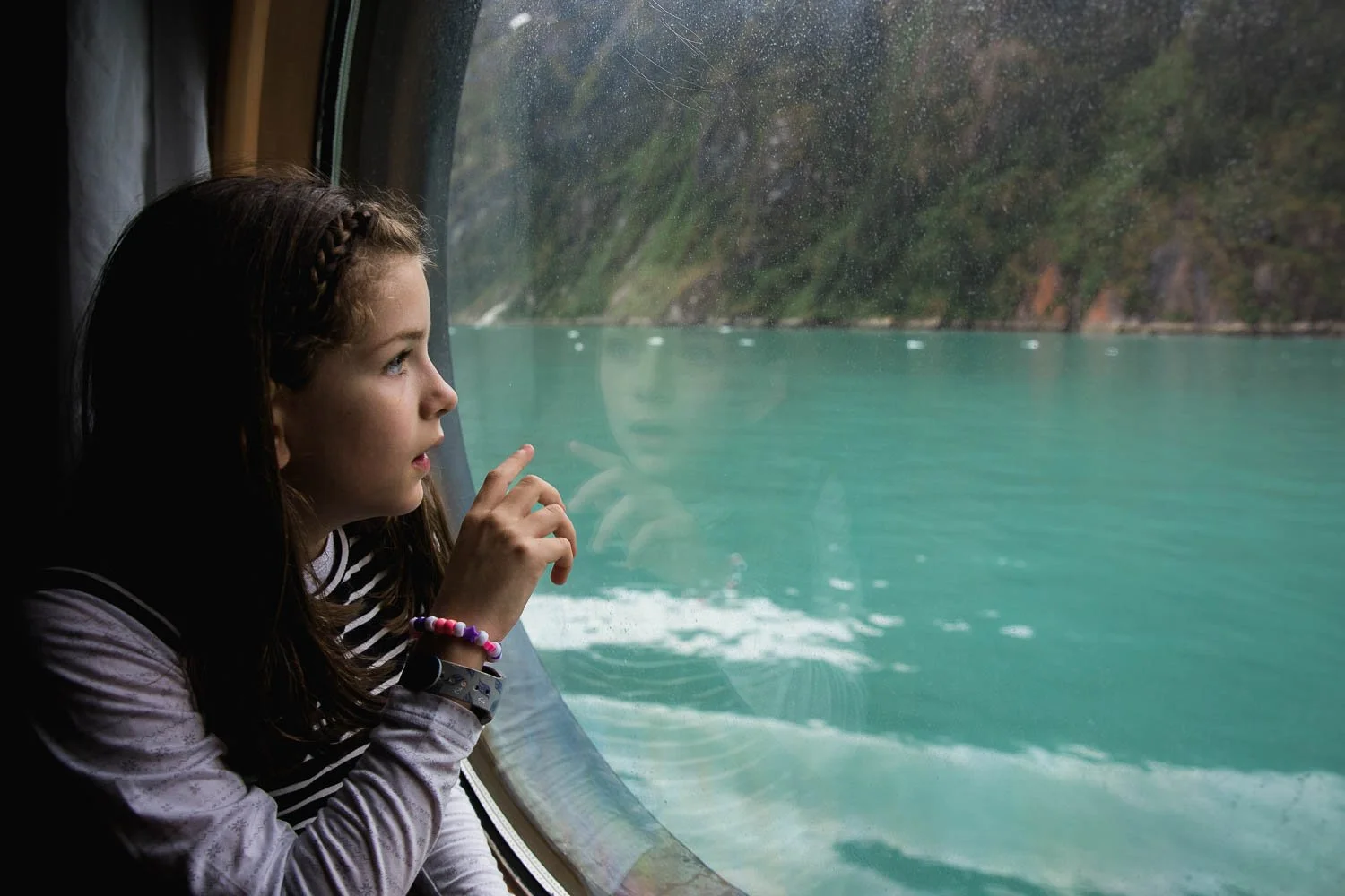 Little girls its in a port hole admiring the views outside her oceanview room on the Disney Wonder.