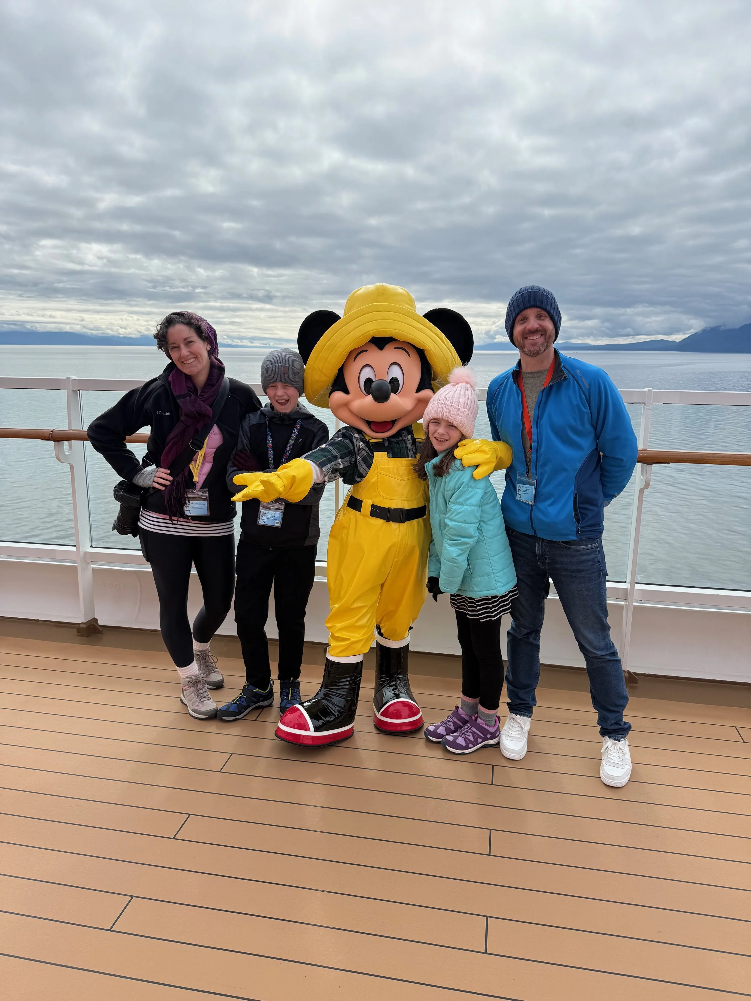 Family poses for a photo with Alaska Mickey on the Disney Wonder.
