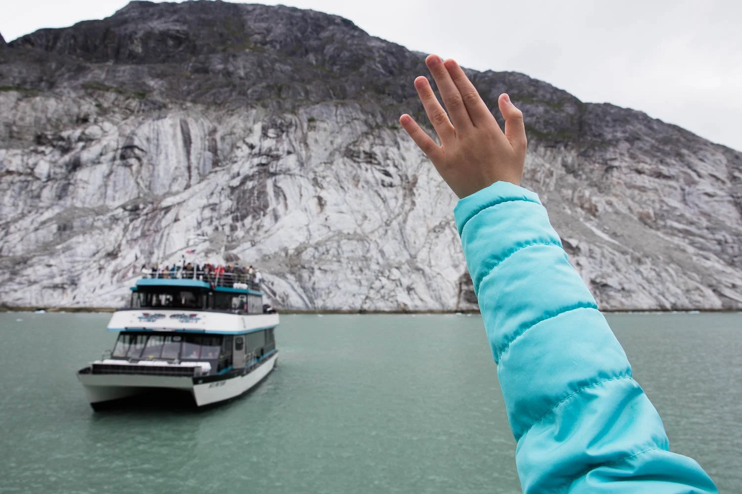 Tween waves at a boat from her Alaska fjord excursion.