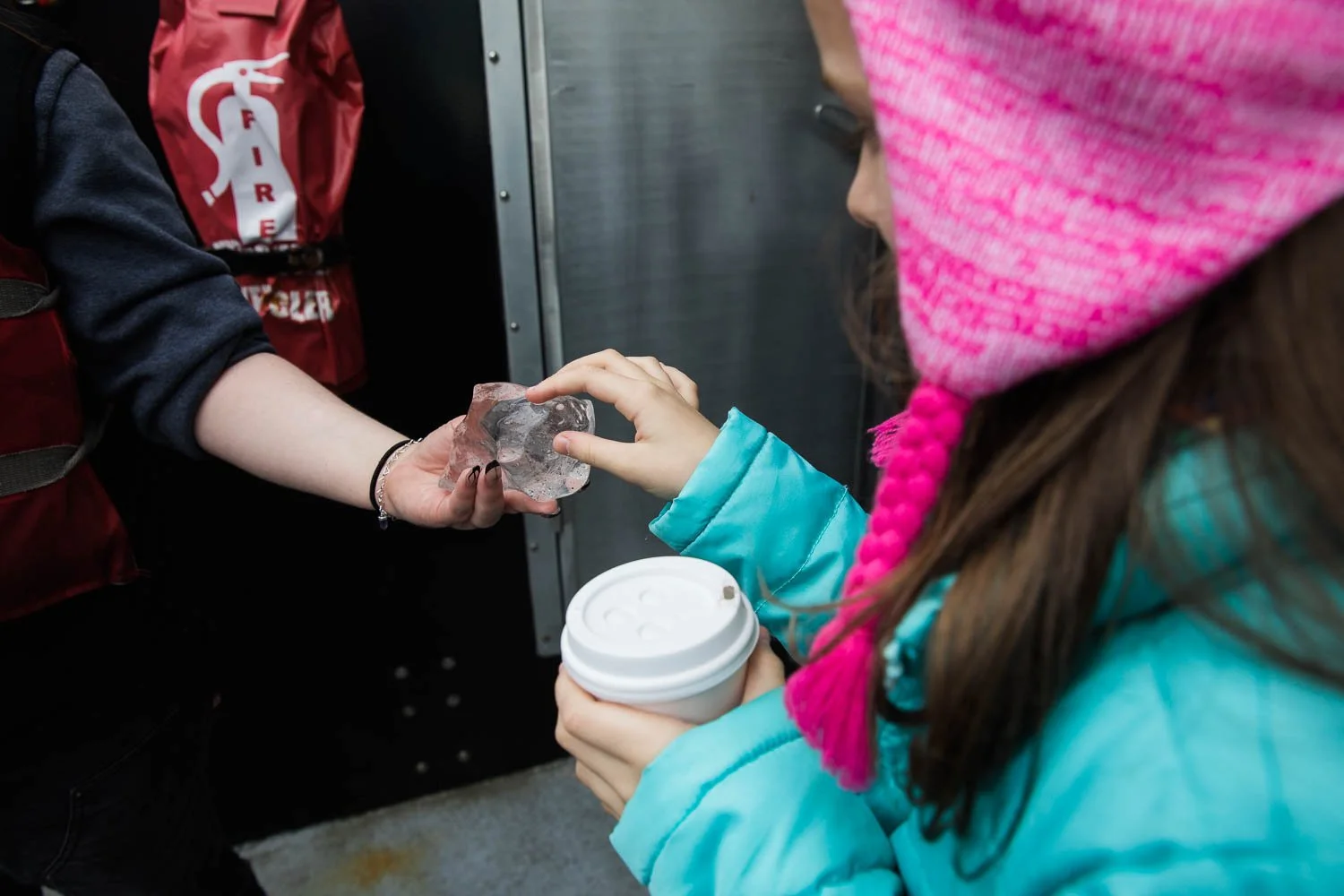 Excursion guide shows kids Alaska glacier ice.