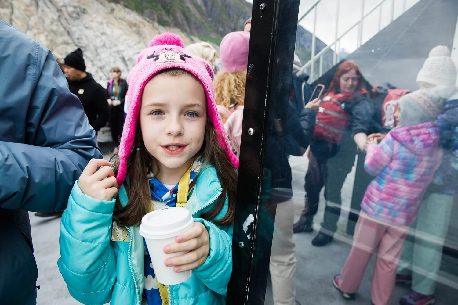 Girl walks around boat with her hot cocoa.