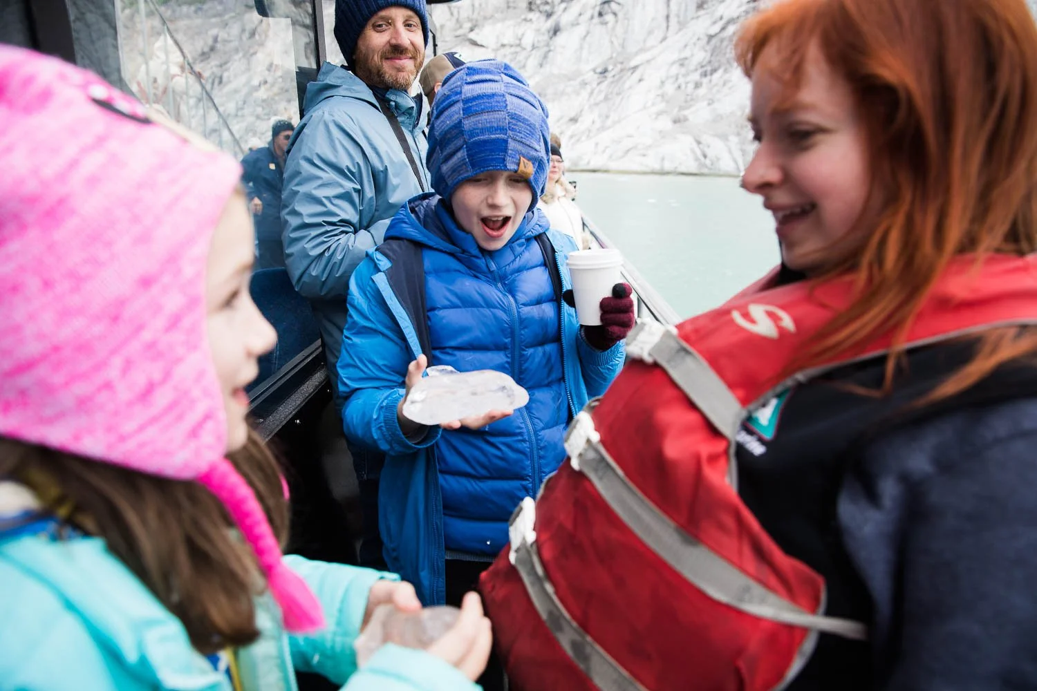 Excursion guide shows kids Alaska glacier ice.