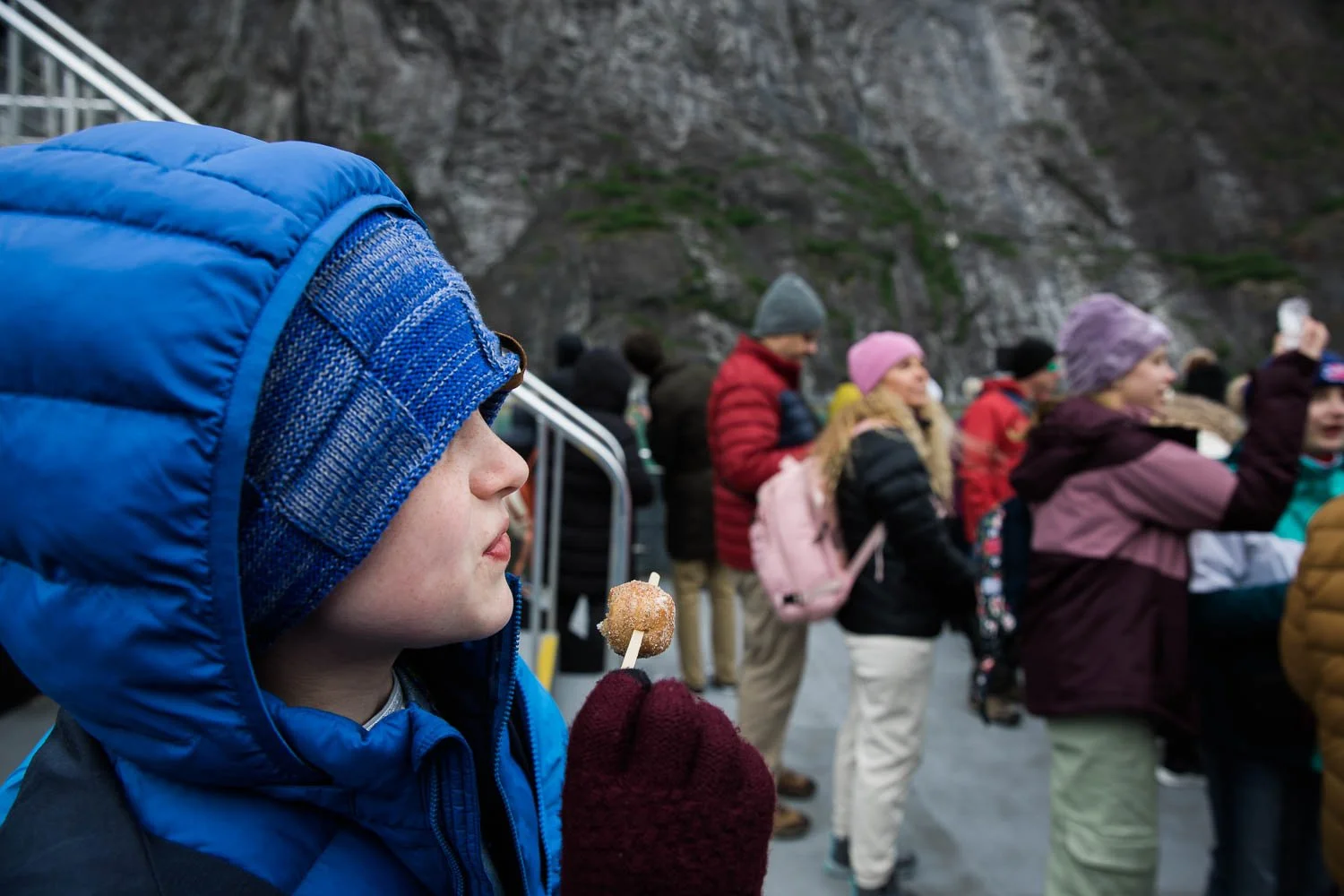 Boy eats a doughnut on a boat in Alaska.