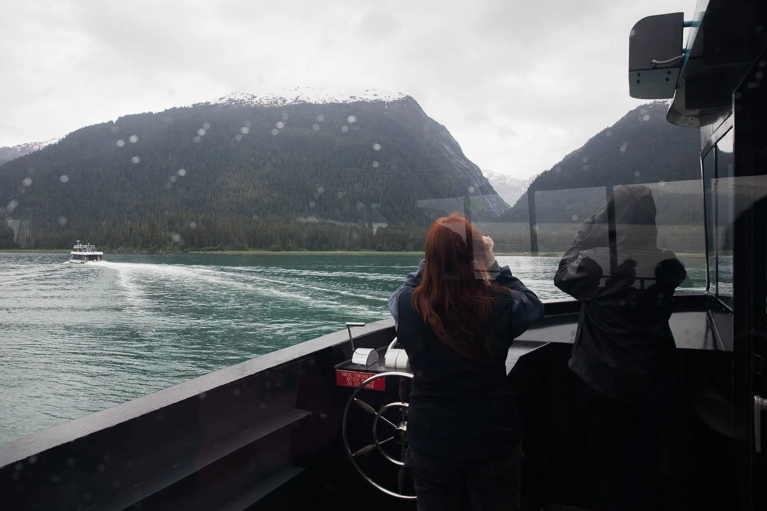 Excursion guides look for wildlife from boat in Alaska.