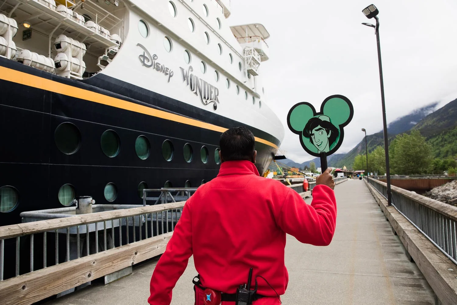 Disney cast member leads tour group off of the Disney Wonder ship.