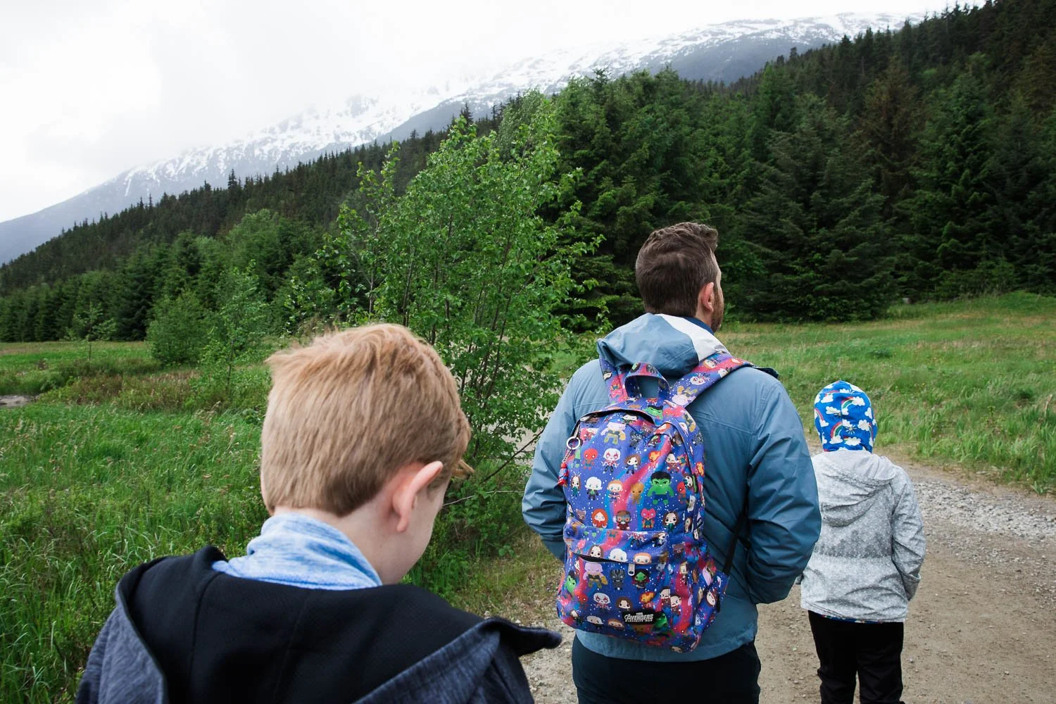 A father walks with his kids through the mountains of Skagway, Alaska.