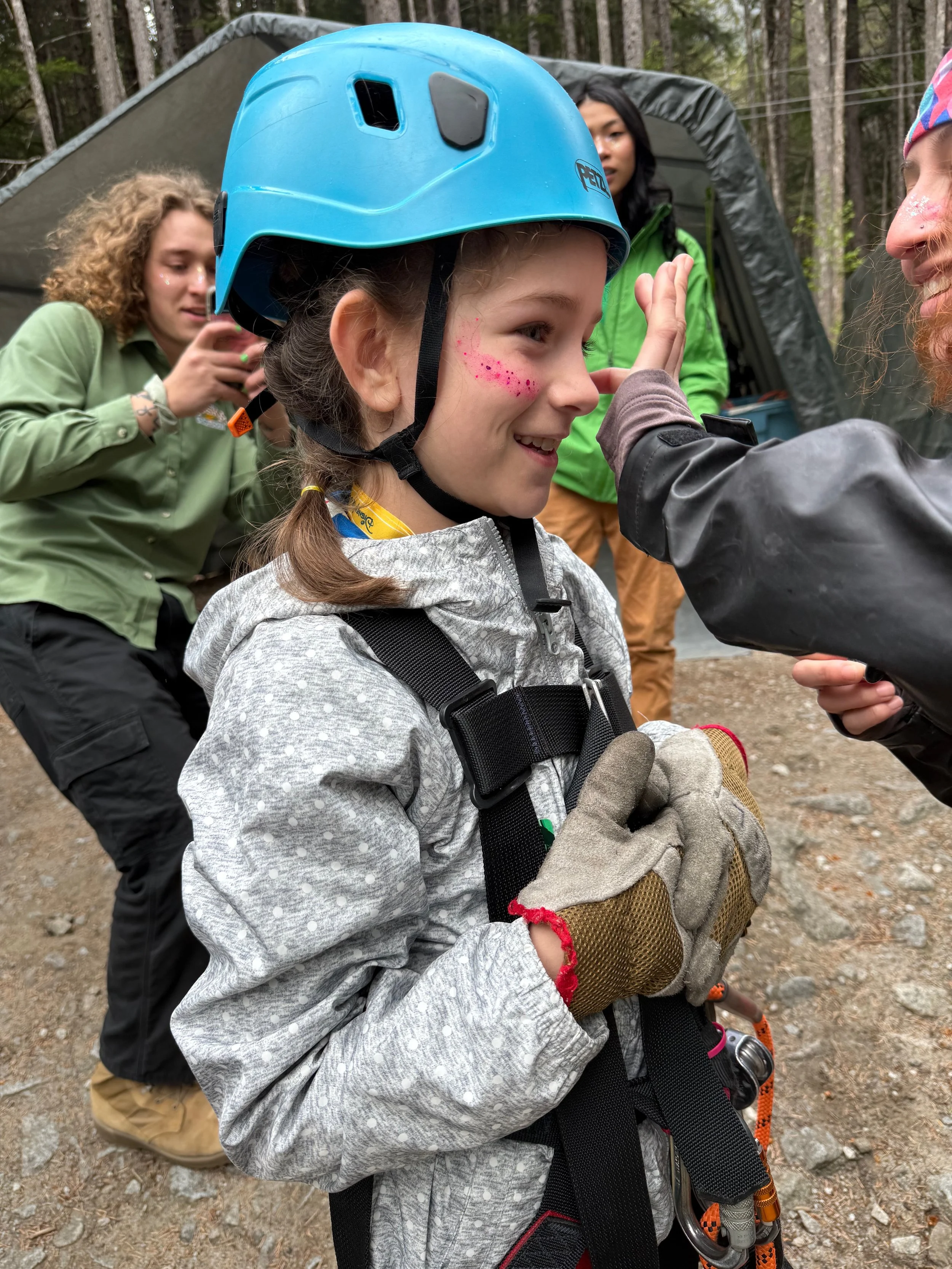 Little girl gets sparkles on her face before her first ziplining excursion in Alaska.