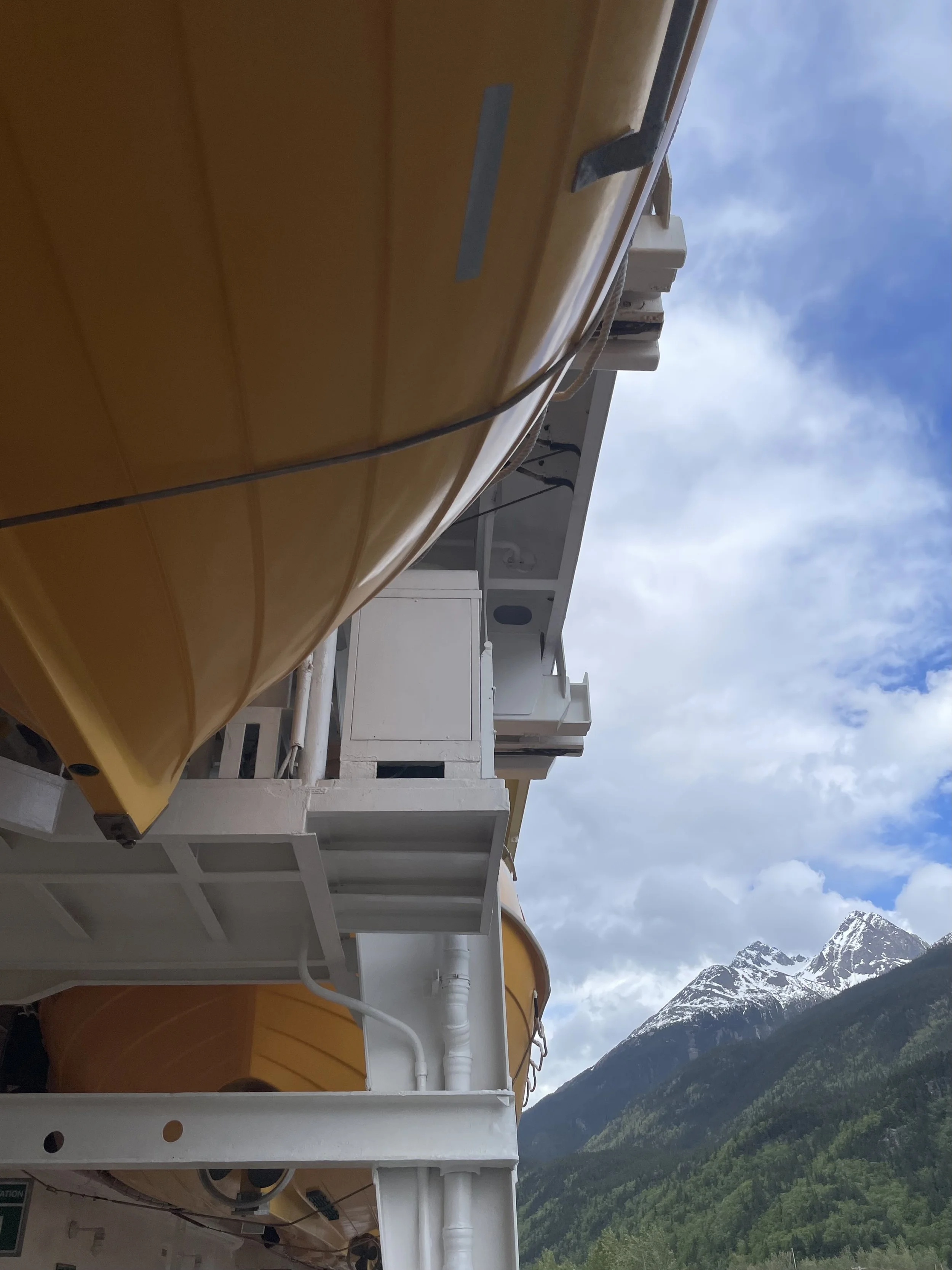 View of Disney Cruise lifeboats and mountains in Skagway, Alaska.