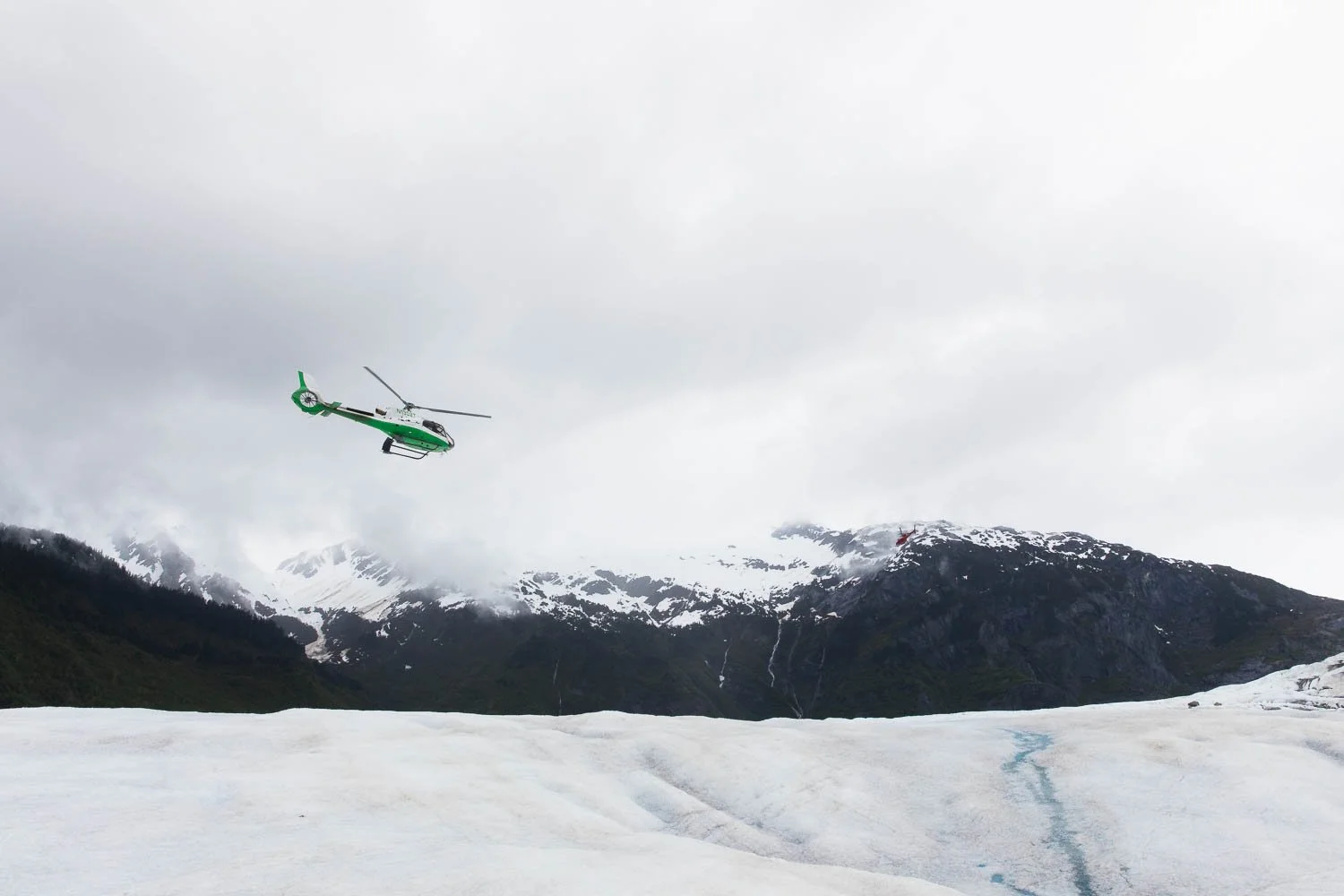 Helicopter soars above Mendenhall Glacier in Juneau, Alaska.