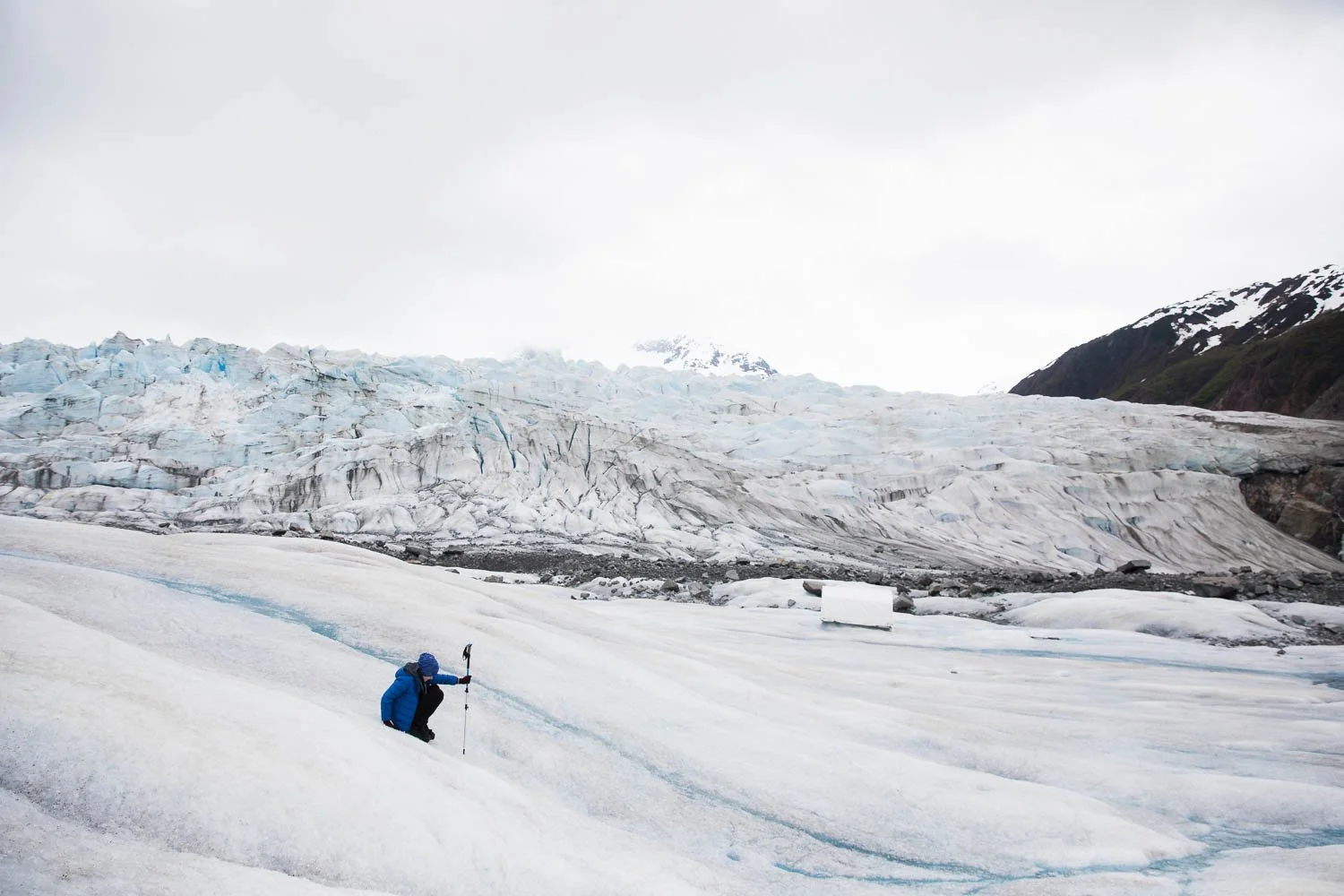 Kid slides down the slope of a glacier in Alaska.