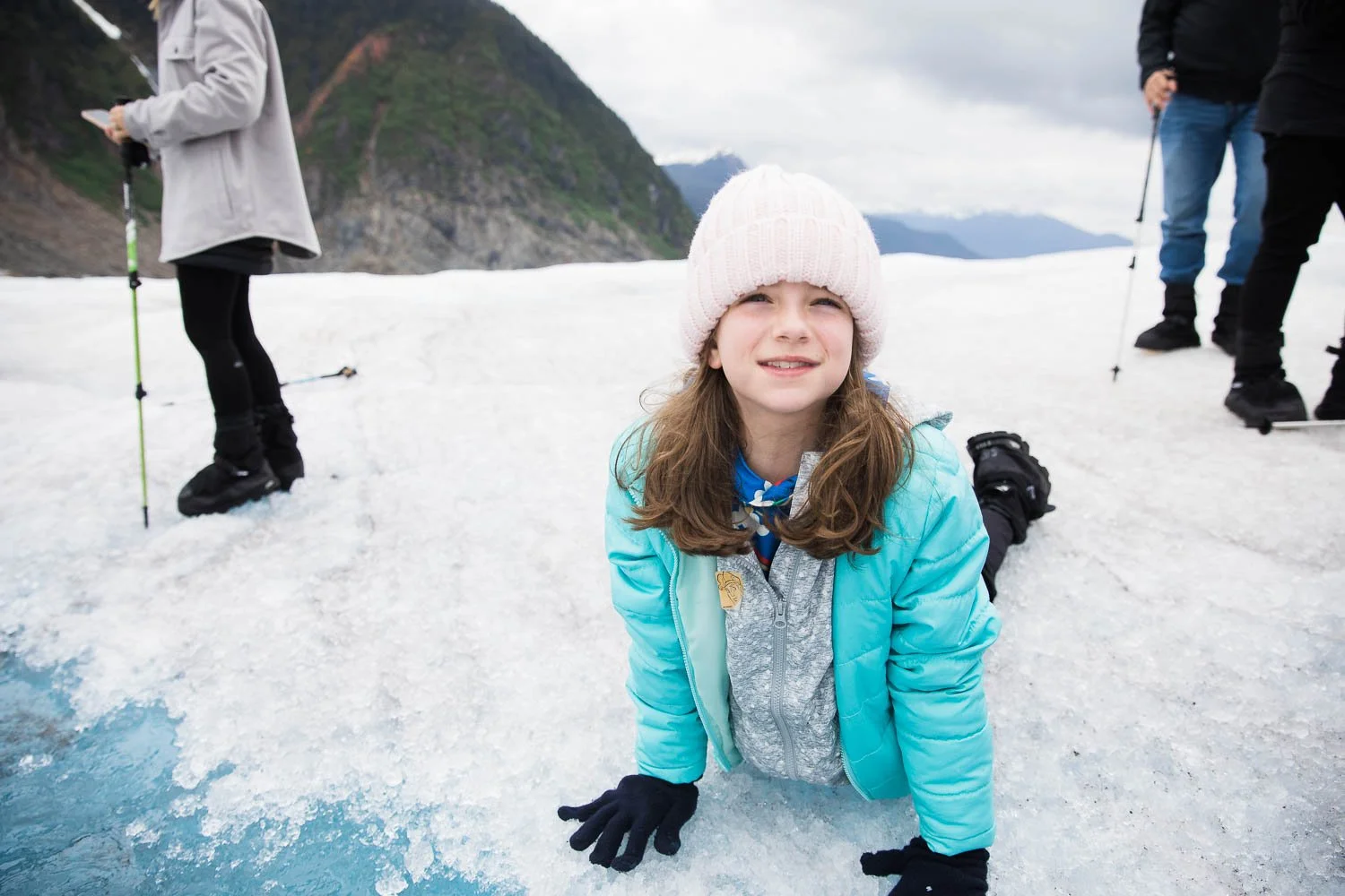 Kid drinks glacier water in Alaska.