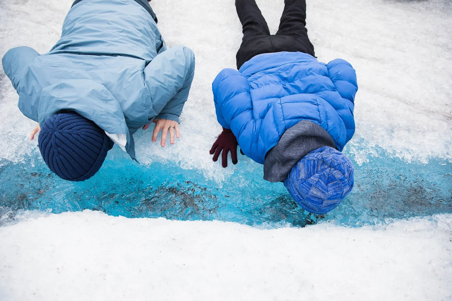 father and son drink glacier water on Mendenhall Glacier in Alaska.