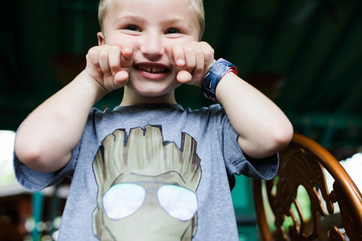 Little boy makes elephant tusks with his fingers.