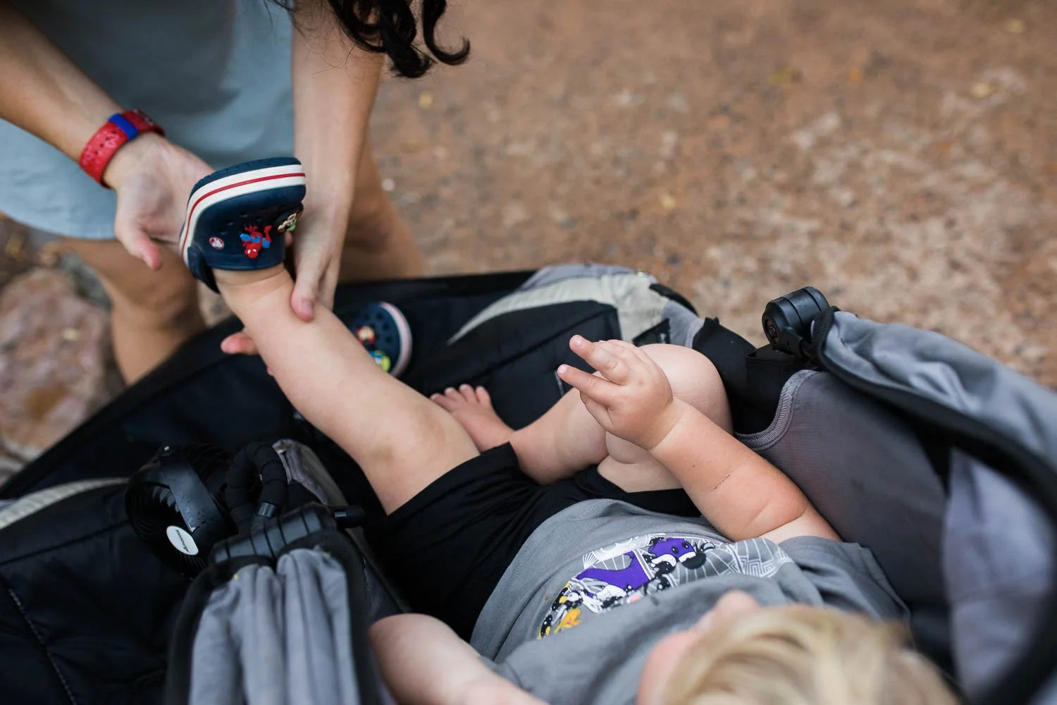 Mother fixes toddlers shoes at the Animal Kingdom.