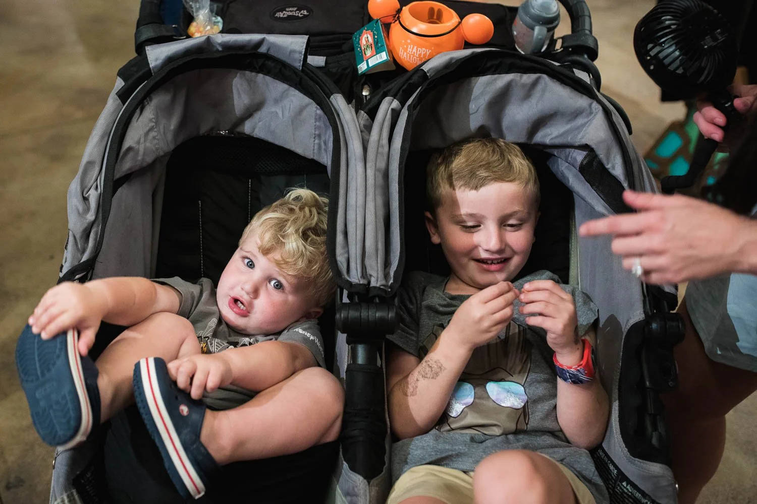 Boys sit in a stroller.