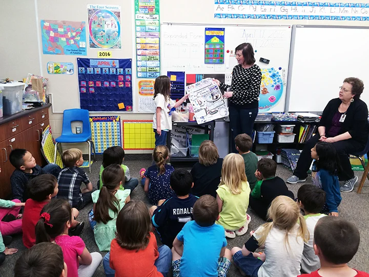 Abbey and Shauna sharing Abbey's "All About Me" birthday poster to her class. 