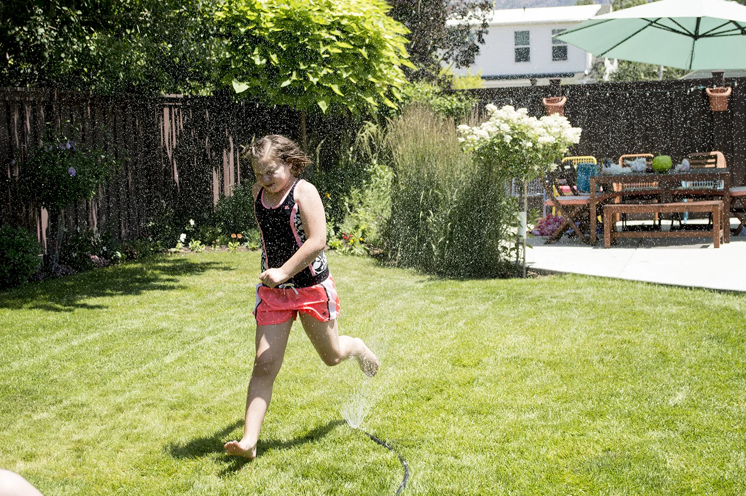 Marisa running in the sprinkler.
