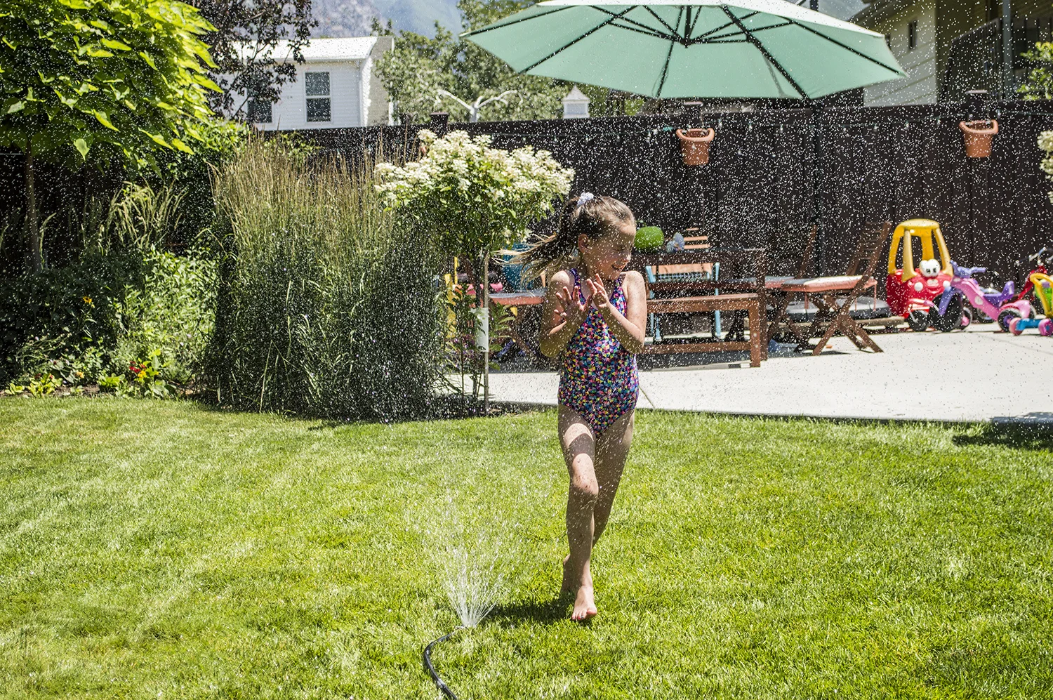 Maliya running in the sprinkler.