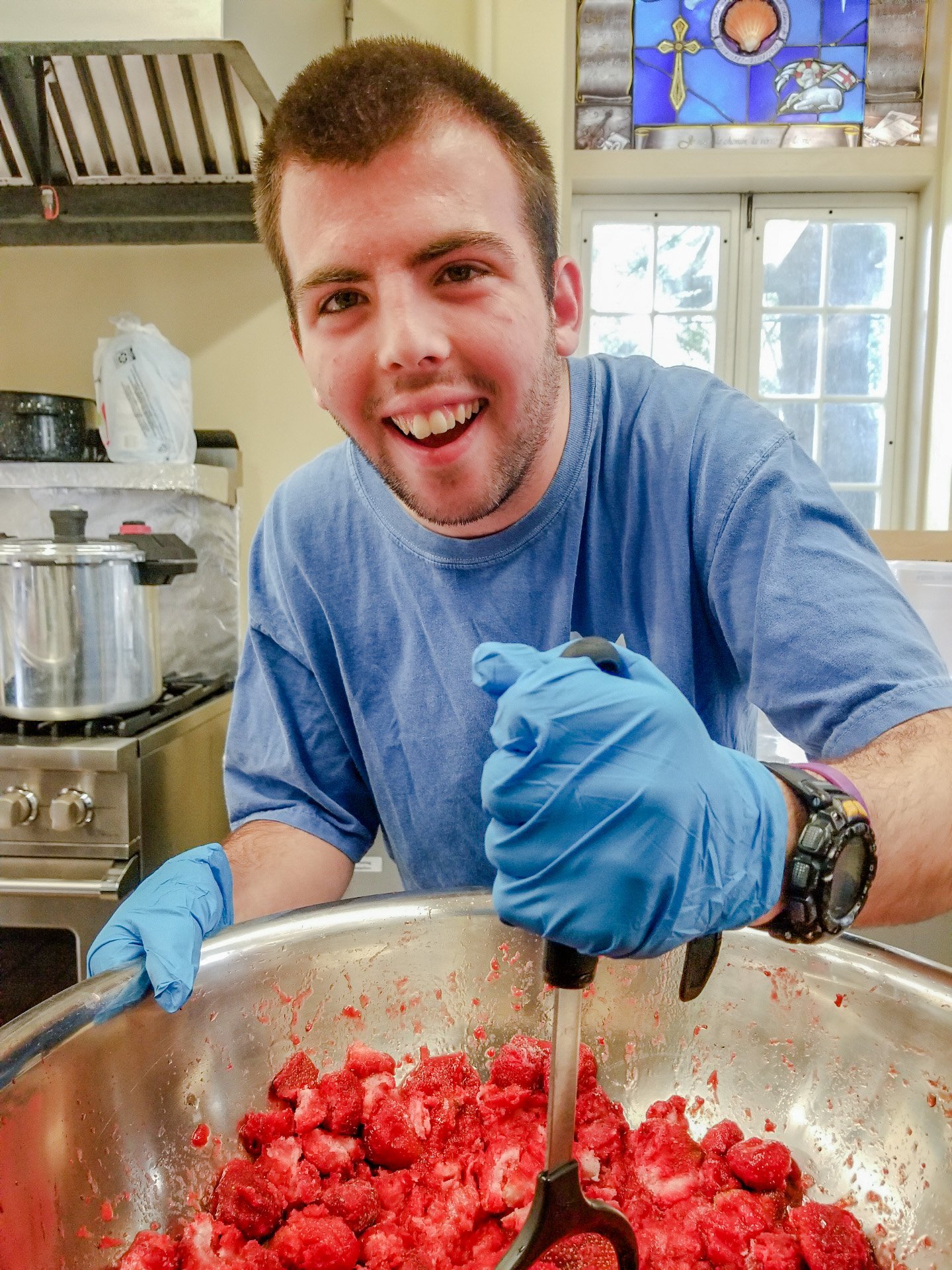 Grower Casie mashing strawberries for making jam.JPG